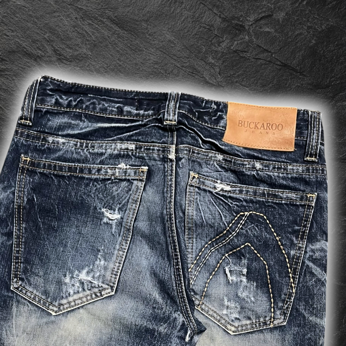 streetcave.eu Buckaroo Jeans aus dunkelblauem Denim mit Distressed-Details, Vintage-Waschung und Leder-Label am Bund.