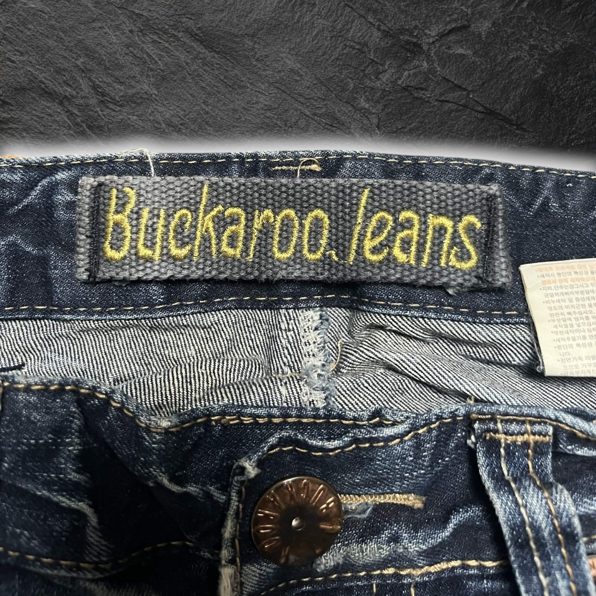 streetcave.eu Buckaroo jeans Denim-Hose mit gelbem Logo-Aufnäher und markanten Nähten auf dunkelblauem Stoff