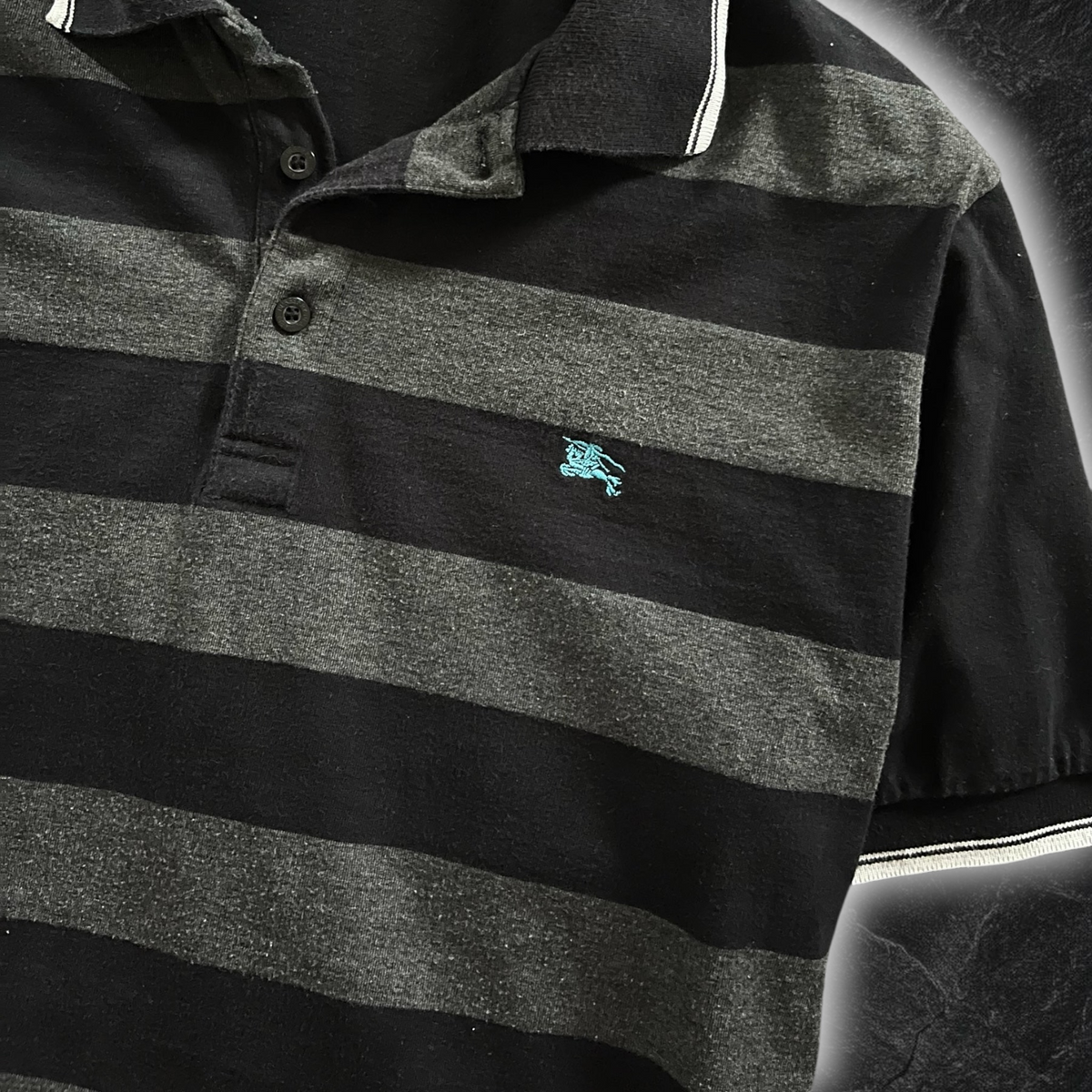 streetcave.eu Burberry Black Label Poloshirt in Schwarz und Grau mit gestreiftem Muster und türkisfarbenem Logo