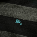 streetcave.eu Burberry Black Label Poloshirt mit schwarz-grauem Streifenmuster und türkisfarbenem Logo-Stick