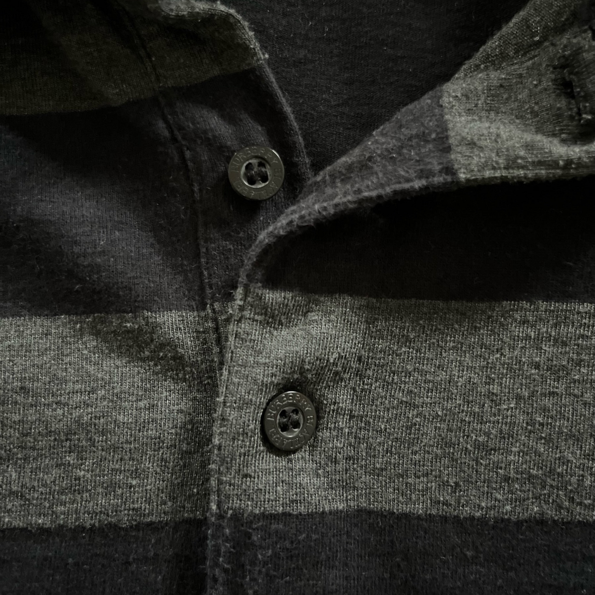 streetcave.eu Burberry Black Label Poloshirt mit schwarz-grauem Streifenmuster und gravierten Knöpfen